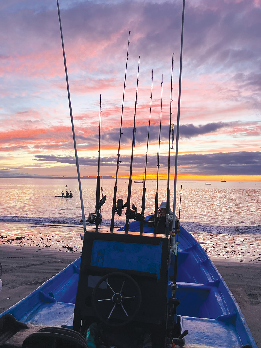 The fishing boat on shore as the sun rises. 